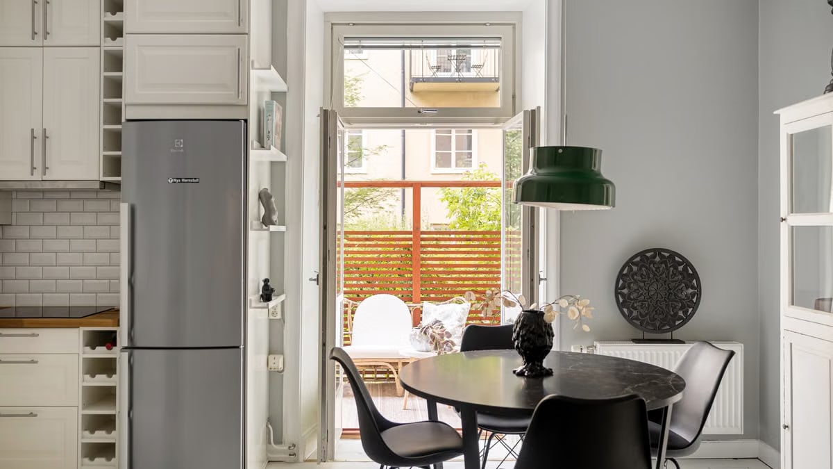 Elegant kitchen with black chairs, round table, and modern décor.